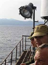 Travelers weary from the ferry watch Sakhalin Island approach.