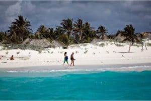 Tourists walk along the beach in front of Zazilkin, a hotel with rustic cabanas in Tulum, on the Yucatán Peninsula. Photo by Michael Nagle.