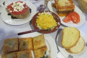 Assorted mezedes, including dakos, fava beans, moussaka and kalitsounia, pies filled with local greens.