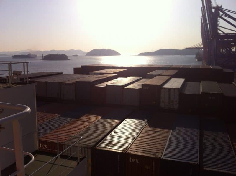 Containers line the decks of a container ship that takes passengers, docked in South Korea.