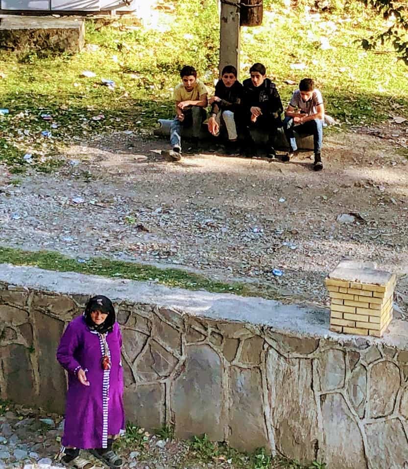 Residents of Sheki near an old stone wall