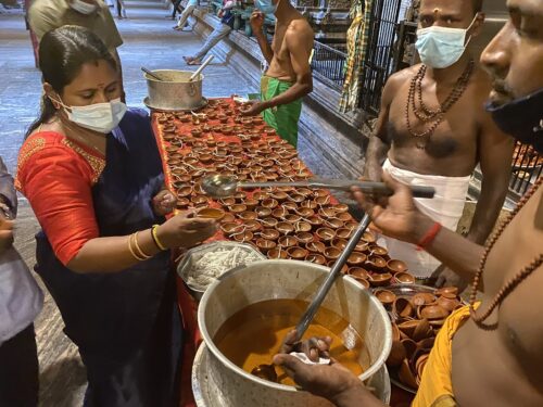 The vilakkus, small clay lamps, are filled with oil from the pot and left lit at the shrine of the worshiper's choosing.