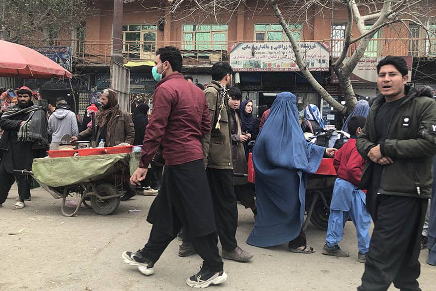 A DAY IN KABUL- A typical street market in Kabul. Notice the full blue Chador the two women are wearing. This type of veil is largely unique to Afghanistan.