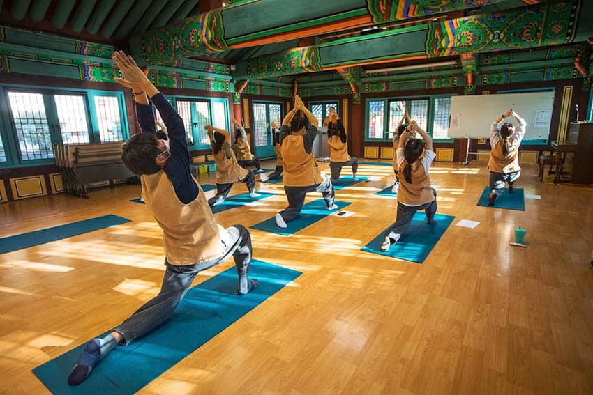 At Jeungsimsa Temple's yoga session, participants engage in stretching routines (Photo by Cultural Corps of Korean templ Buddhism) Temple Stays