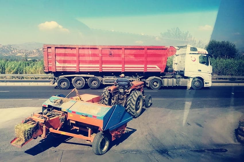 Free-way entrance, lorries flying by, view from bus window on road to Pamukkale.