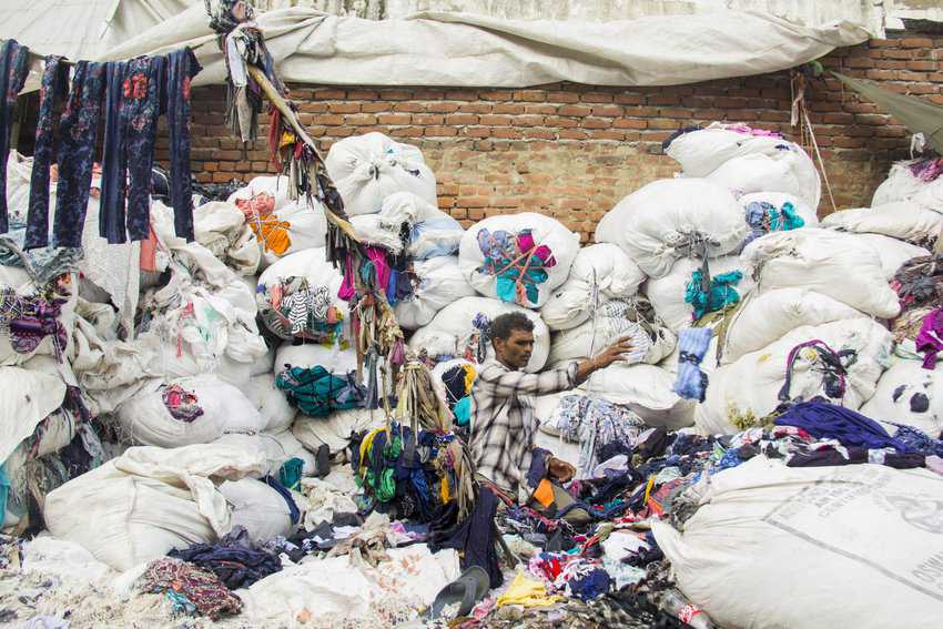 A worker sorting through the waste in a recycling plant