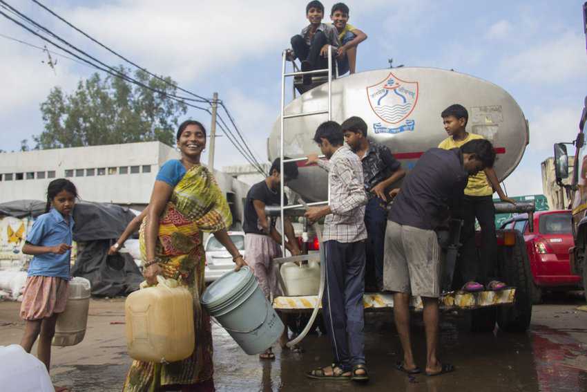 People collect water from the tanker