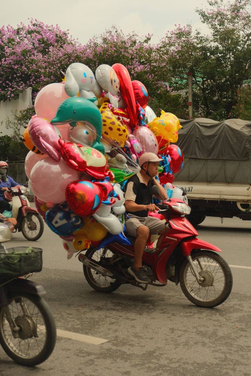 Man hauling balloons in Hoi An. Photo by Evan Glassman