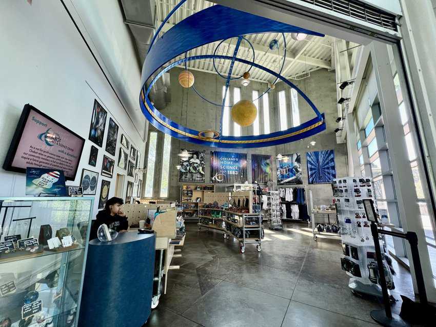 The interior of the Chabot Space and Science Center gift shop, featuring vibrant colors and a large central art installation that captivates visitors.