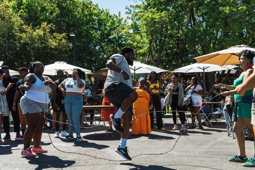 Lakefest: A vibrant celebration of Oakland's festival spirit, featuring a large man energetically jumping double Dutch rope amidst a lively crowd.