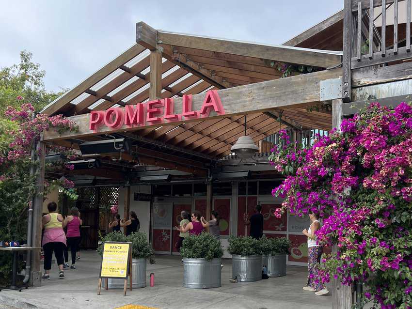 Women participating in a Zoom class on the patio of Pomella, a restaurant on Piedmont Avenue.